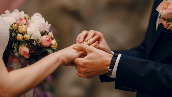 groom placing ring on bride's finger